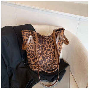 Detail of leopard print bucket bag on sofa with leather straps and large capacity