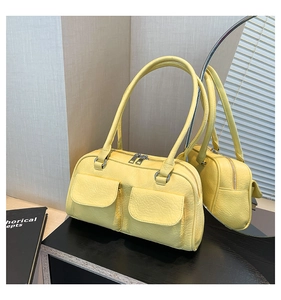Detail of yellow lychee leather bag showing exterior pockets and silver metal hardware