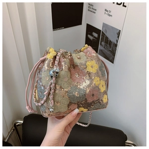 Dettaglio borsa a secchiello con paillettes floreali, coulisse rosa e catena in argento