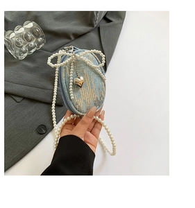 Détail du mini sac en denim avec nœud en perles et sequins sur bandoulière perle