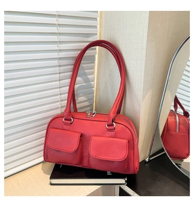 Detail view of red leather underarm bag with double front flap pockets and silver hardware
