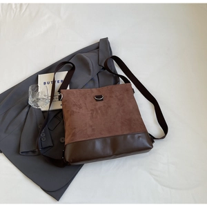 Detail of suede and leather patchwork crossbody bag with silver D-ring and web strap