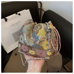 Dettaglio borsa a secchiello floreale con paillettes e tracolla a catena