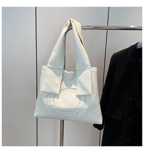 Detail view of white lychee texture tote bag with abstract black circular pattern