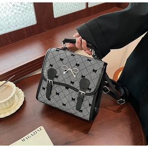 Close-up of retro plaid backpack with embroidered bow and silver metal buckle detail