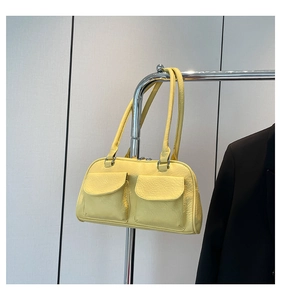 Detail view of yellow vintage shoulder bag with pleated texture and double front pockets