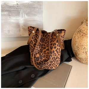 Close-up of leopard print faux suede bucket bag with leather strap and gold rivet details