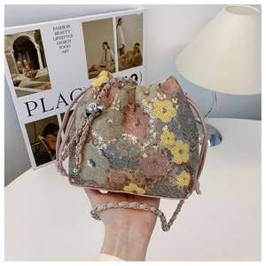 Dettaglio della borsa a secchiello con paillettes floreali, catena e perla metallica