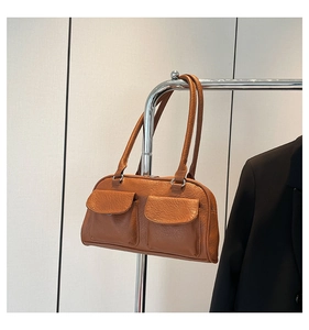 Detail of vintage brown shoulder bag with double flap pockets and wrinkled leather texture