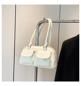 Detail of white lychee leather shoulder bag with dual flap pockets and silver hardware