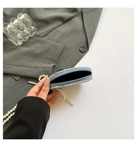 Détail du mini porte-monnaie à paillettes bleu clair avec une chaîne en perles