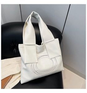 Detail of white large capacity tote bag with circular quilted pattern and wide strap