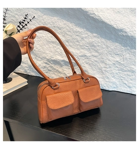 Detail of vintage brown textured leather shoulder bag featuring dual front flap pockets