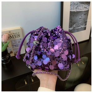 Dettaglio borsa a secchiello con paillettes viola, chiusura a coulisse e catena argento