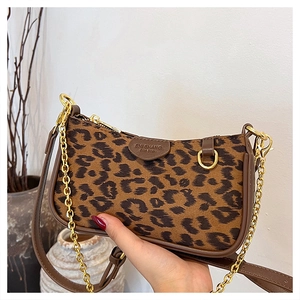 Detailed shot of leopard print handbag with golden chain and adjustable leather strap