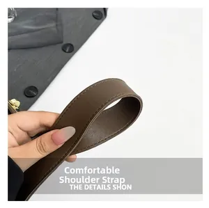 Close-up of durable brown leather shoulder strap with precision stitching and thick texture