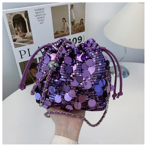 Dettaglio ravvicinato di paillettes viola e catena d'argento su una borsa a secchiello