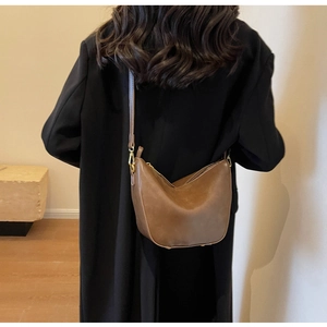 Brown vintage hobo bag shown on model highlighting the adjustable shoulder strap and size