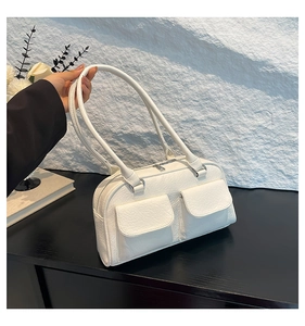 Detail view of white underarm bag with textured leather and dual front flap pockets