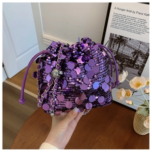 Dettaglio delle paillettes viola e della chiusura a coulisse in pelle della borsa