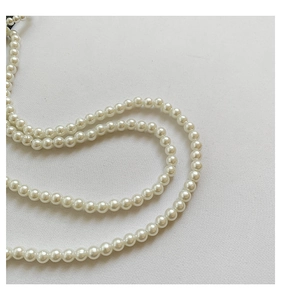 Gros plan sur une élégante chaîne de perles blanches avec une texture lisse et brillante