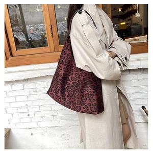 Detailed close-up of large burgundy leopard print tote bag in premium glossy fabric