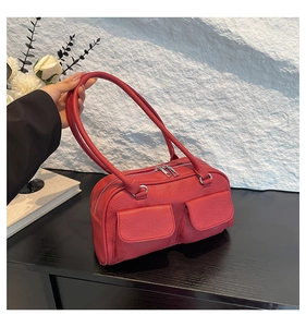 Detail of red vintage underarm bag with wrinkled texture and double front pockets