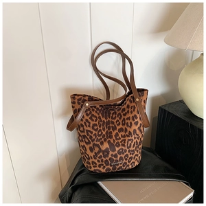 Macro detail of the leopard print faux fur texture and leather handle on bucket bag