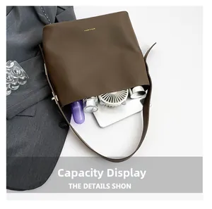Macro detail showing large capacity storage for tablet and cosmetics in brown bucket bag
