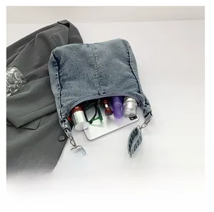 Flat lay of retro blue denim crossbody bag showing interior storage for phone and makeup