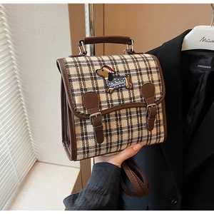 Detail view of vintage plaid backpack with dachshund embroidery and leather trim accents