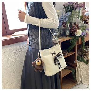 White canvas shoulder bag with aesthetic bow ties and a cute plush puppy charm detail