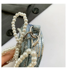 Vue détaillée du mini sac à paillettes bleu clair avec poignée et bandoulière en perles blanches