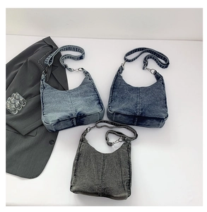 Detailed view of three vintage denim hobo bags showing diagonal stitching and washed texture
