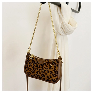 Detail of leopard print mini shoulder bag with gold chain strap and brand leather patch