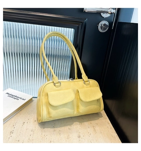 Close-up of vibrant yellow leather handbag featuring dual front pockets and metal zippers