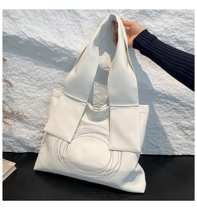 Detail of white large capacity tote bag with circular embroidery and lychee pattern