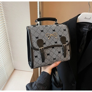Detail showing checkered patterns and a metal bow buckle on this vintage style backpack