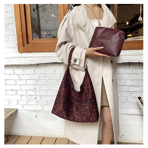 Detail of red leopard print tote bag with a matching burgundy leather clutch
