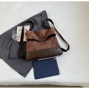 Detailed view of brown mixed-material tote bag with suede and leather textures