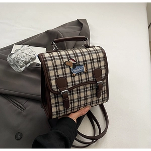 Detail of British style plaid backpack featuring an embroidered dachshund with Christmas hat