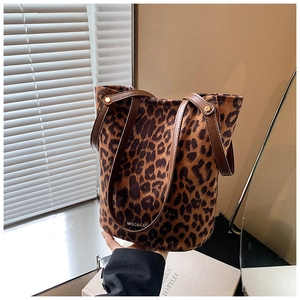 Detail of leopard print bucket bag with suede texture and premium brown leather handles