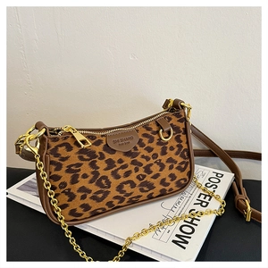 Detail of leopard print hobo bag with brown leather trim and golden metal chain strap