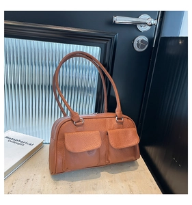 Detail view of vintage brown leather shoulder bag with dual front flap pockets and zippers