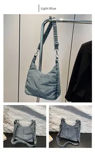 Detail of light blue denim hobo bag with adjustable strap and washed texture finish