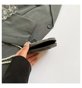 Détail du mini sac à paillettes avec fermeture éclair et chaîne élégante en perles