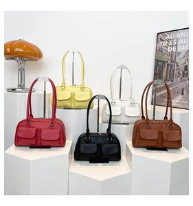 Vintage women's underarm bags in five colors displayed on minimalist white stands