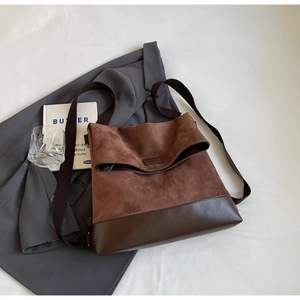 Macro view of brown suede and smooth leather stitching with metal zipper on tote bag