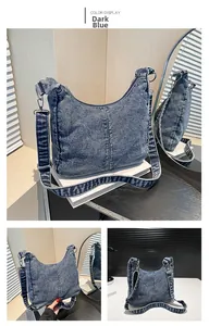 Detail view of deep blue denim shoulder bag with contrast stitching and silver hardware