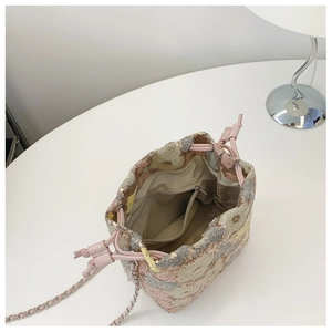 Dettaglio dall'alto della borsa a secchiello con paillettes, coulisse e tasca interna a zip